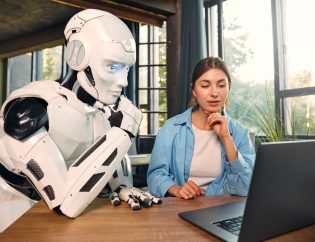 robot and woman working on laptop in office