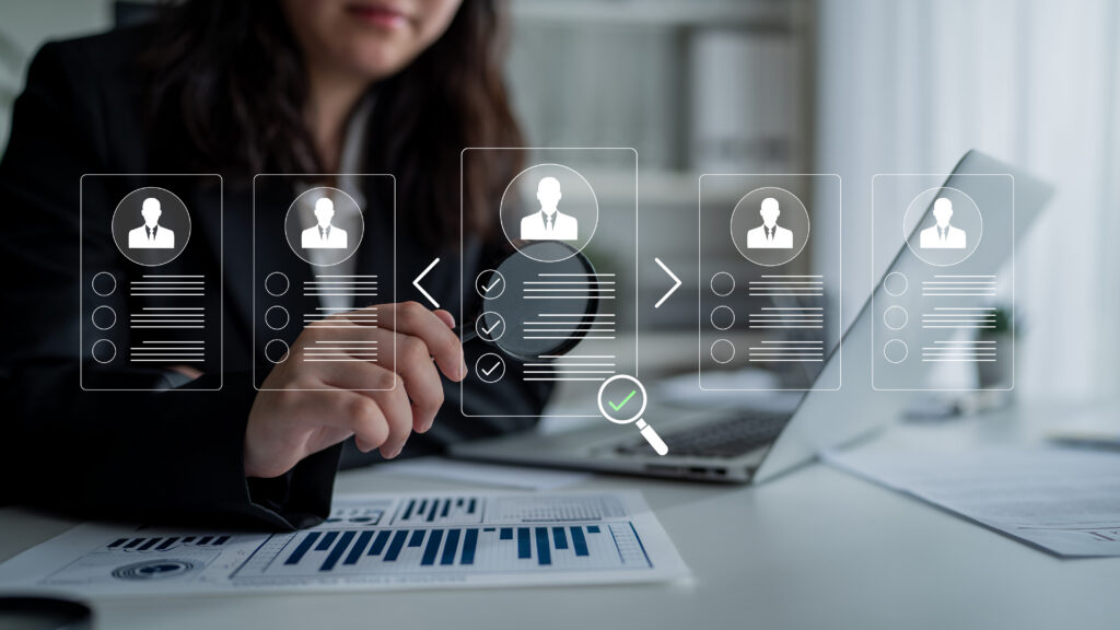 professional businesswoman reviewing resumes and analyzing data in modern office environment with graphs and charts displayed on a laptop screen. glyphic