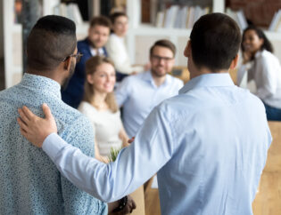 boss introducing black new worker to workmates